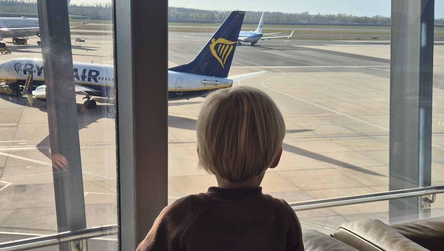 Finn schaut in der Lounge am Flughafen Wien Flugzeugen zu