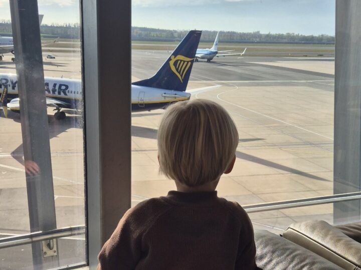 Finn schaut in der Lounge am Flughafen Wien Flugzeugen zu