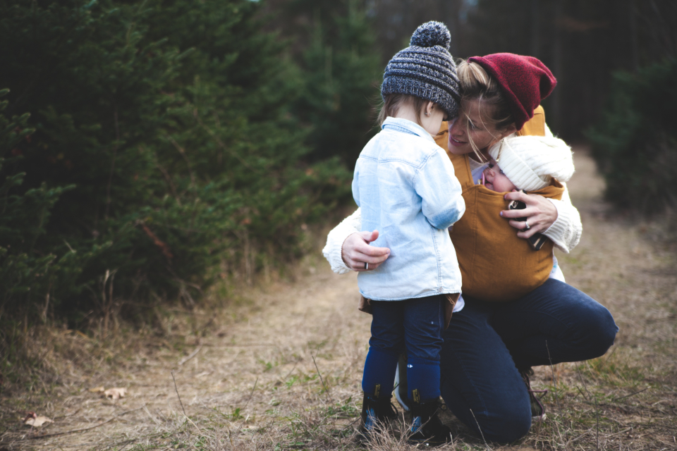 Mutter mit Baby in der Trage und Kleinkind – Reisebuggy Kaufberatung